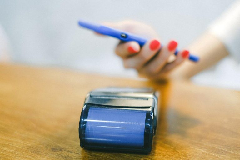Ondernemer gebruikt smartphone voor mobiel pinnen als betaalmiddel bij klant op locatie